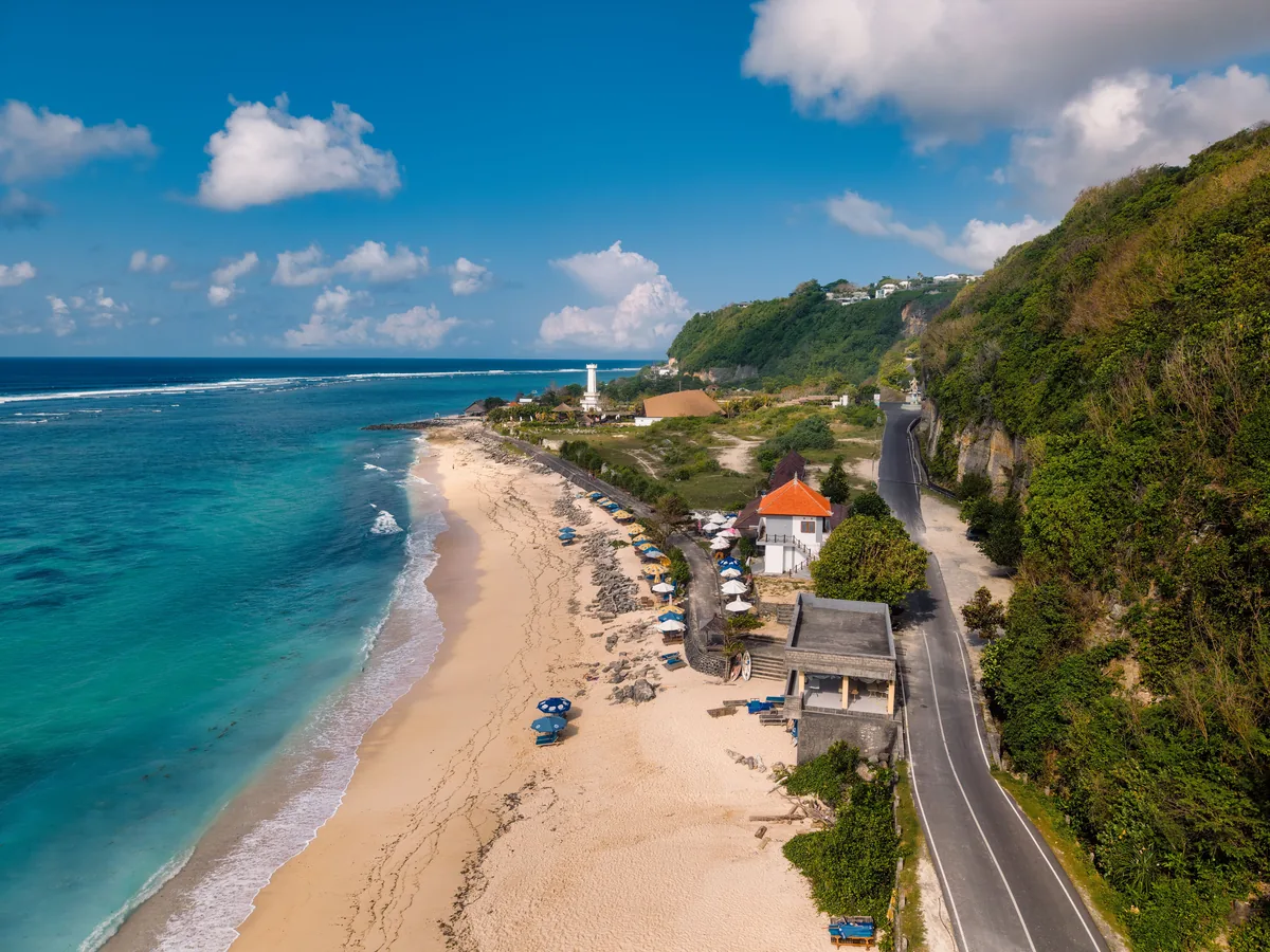 A coastal road running along a beach on the south Bali cliffs